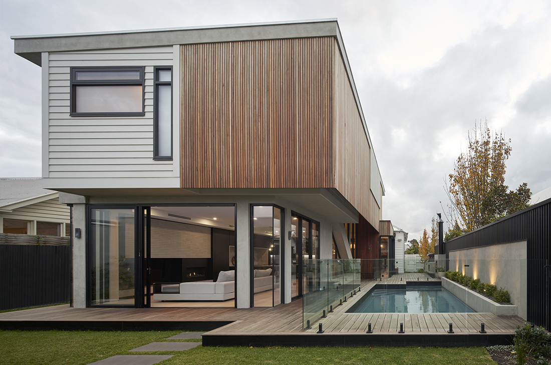 contemporary exterior with timber batten and concrete render overlooking pool