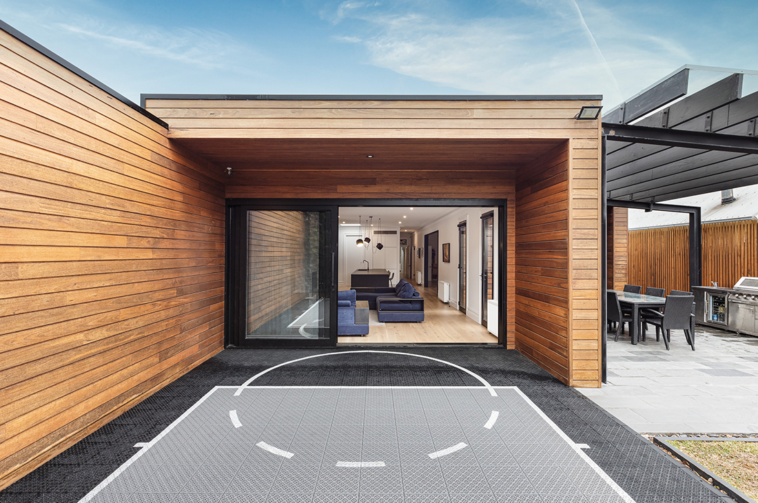 contemporary exterior with timber shiplap cladding, bluestone paving adn basketball court